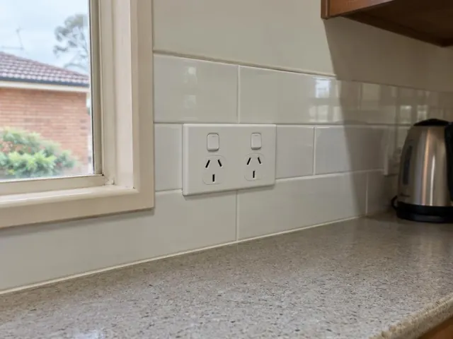 Double power point on tiled kitchen splashback above a benchtop beside a window in Telarah