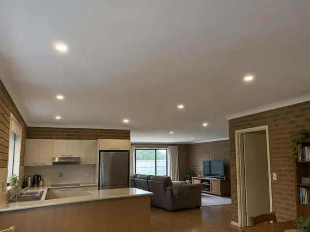Ceiling with recessed LED downlights in a brick-walled open-plan home in Gillieston Heights
